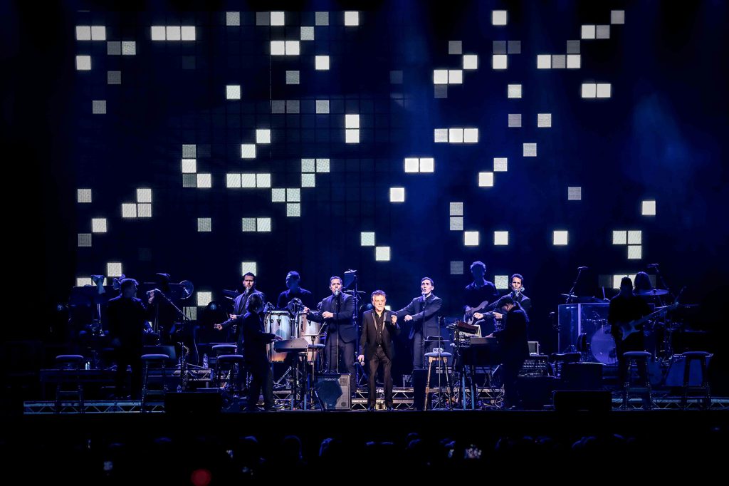 Frankie Valli in concert with a pixellated background